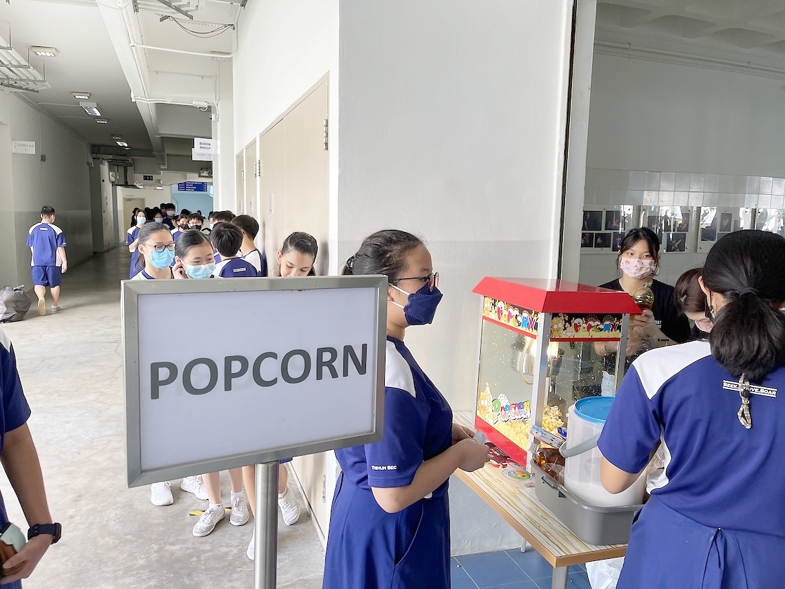 School guests collecting popcorn beside a clearly signed station