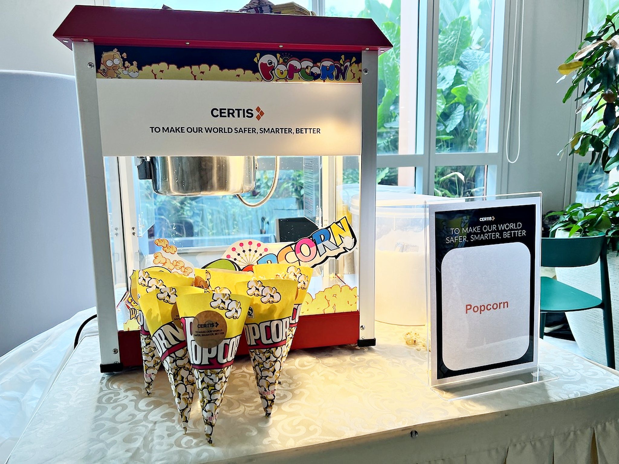 Popcorn machine with branded cones beside a window