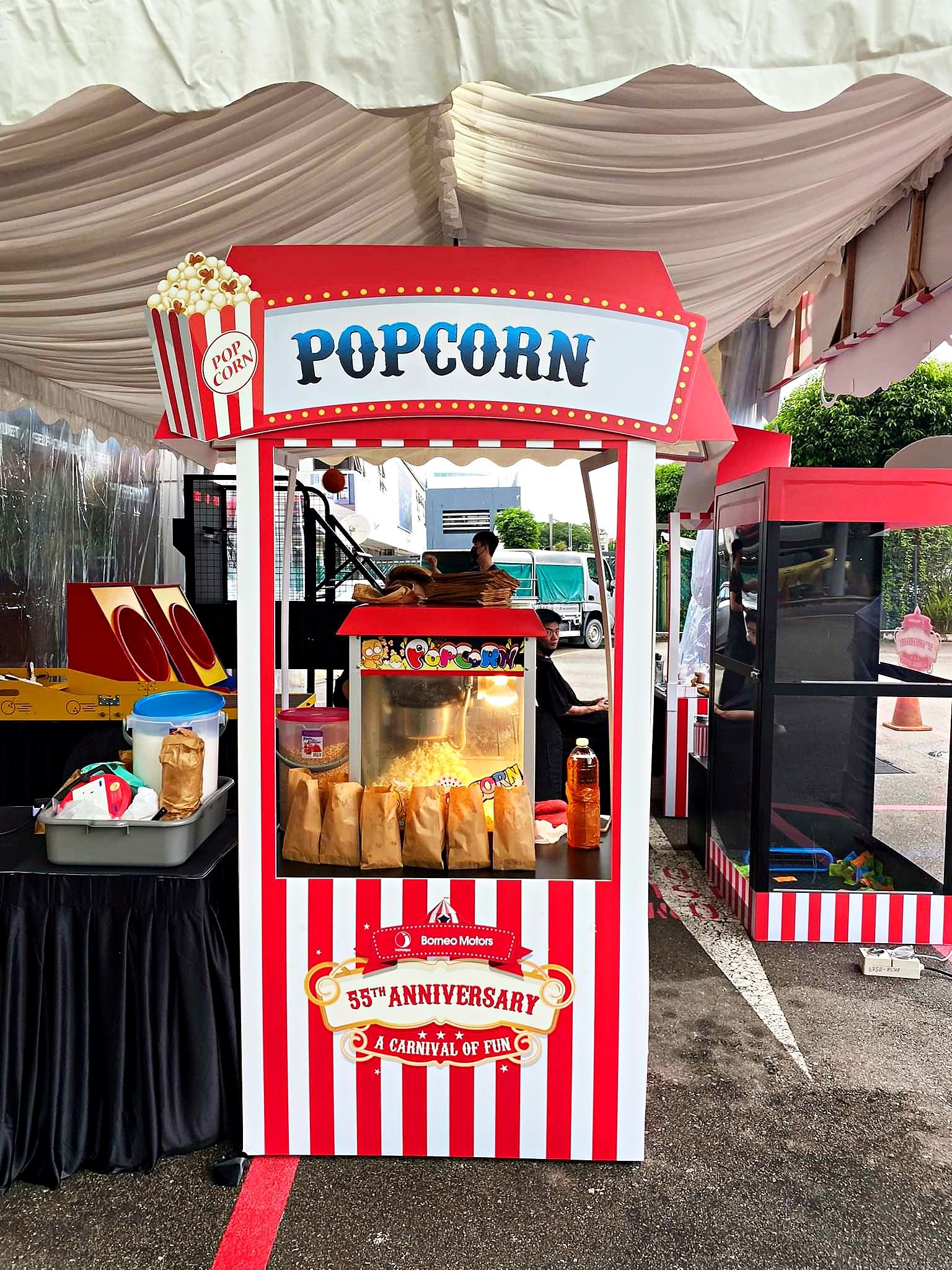 Striped popcorn booth with an overhead sign