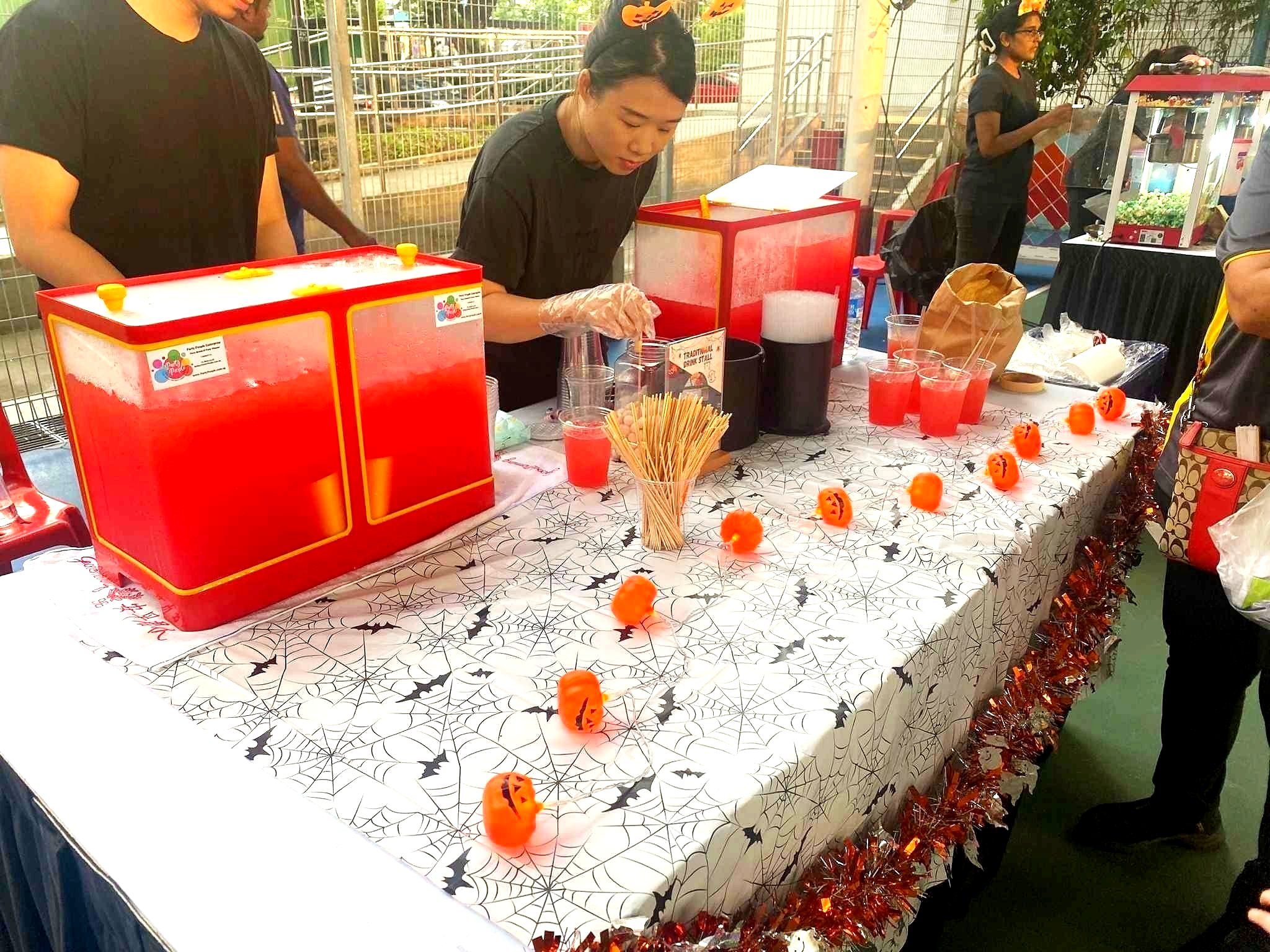Halloween drink counter with red beverages and themed decorations