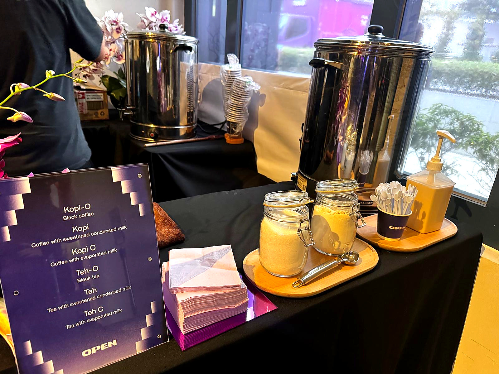 Traditional kopi and teh station with metal urns and a menu