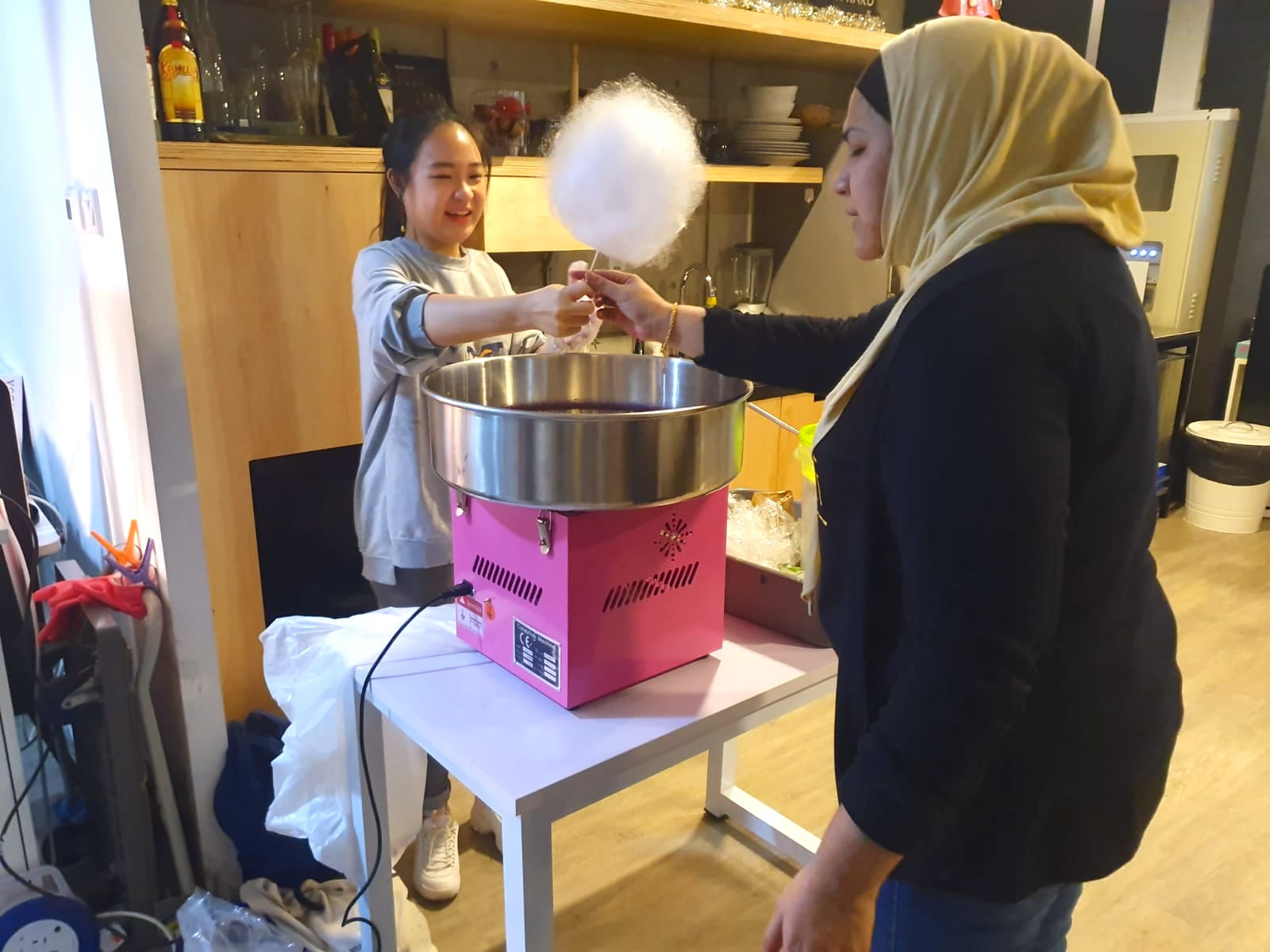 Operator handing candy floss to a guest across a table