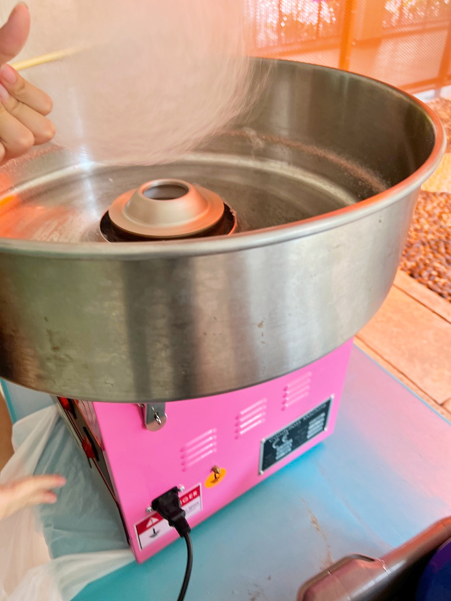Candy floss forming above a metal spinning bowl