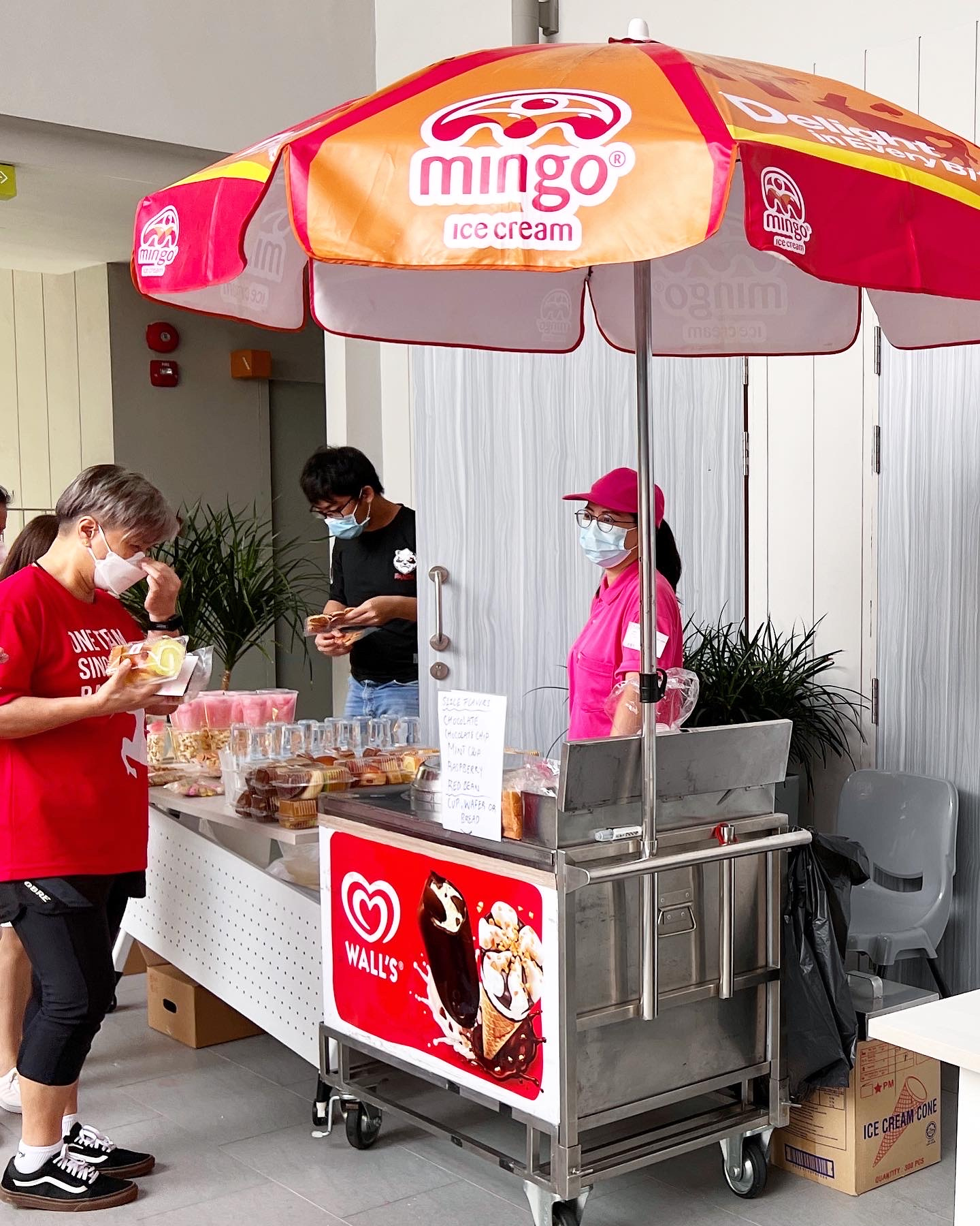 Traditional ice cream cart with a Mingo umbrella and guests