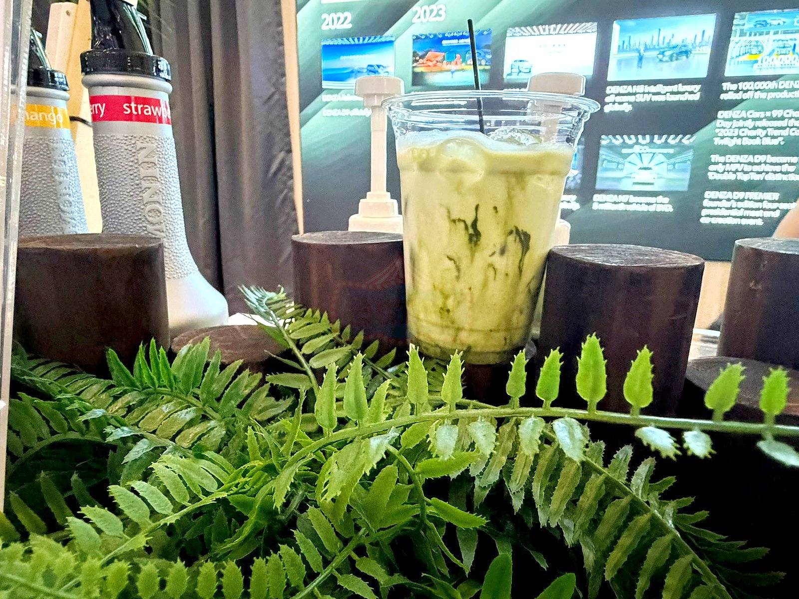 Iced matcha latte displayed on a wooden stand