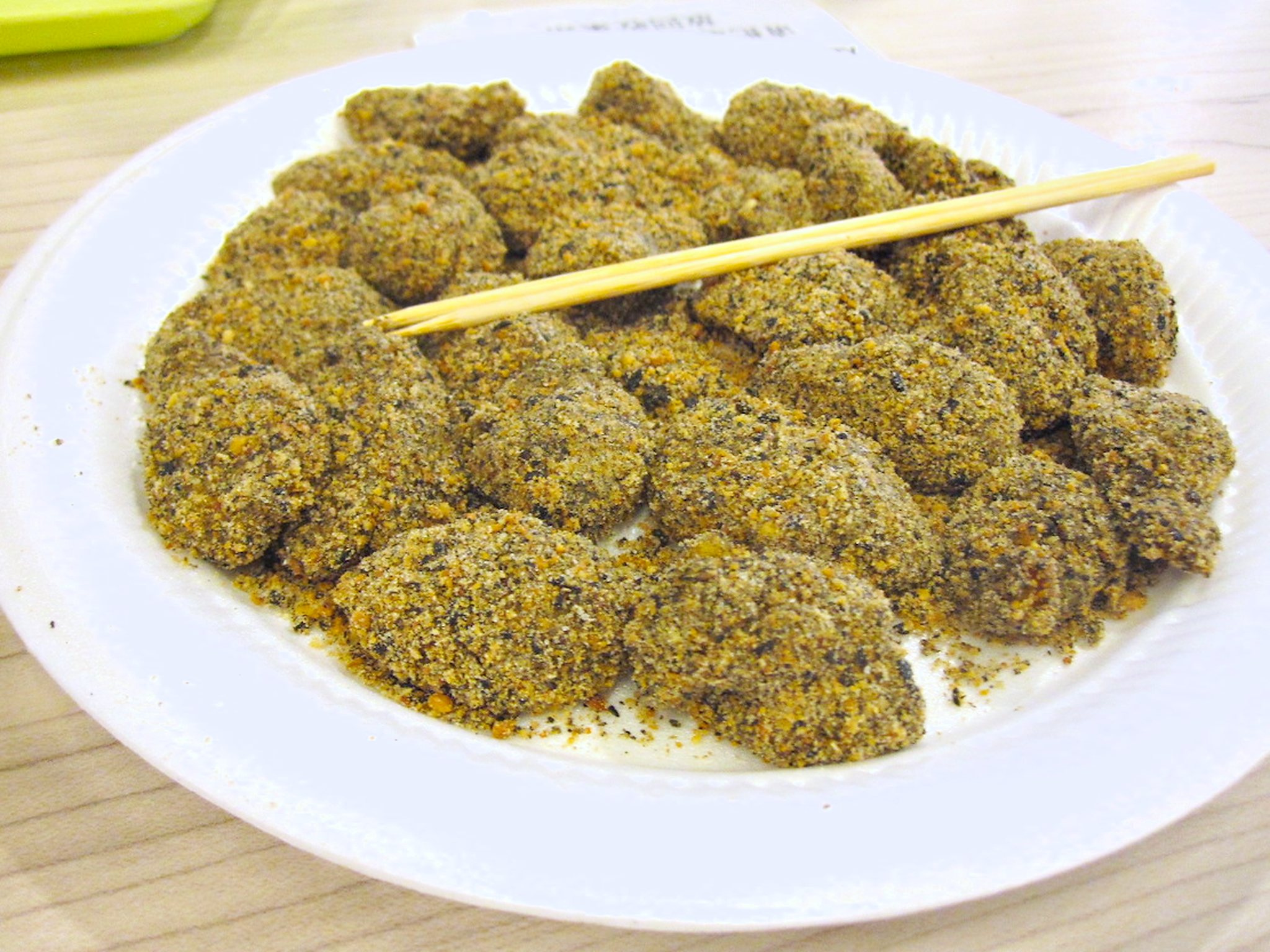 Sesame-coated muah chee pieces on a plate